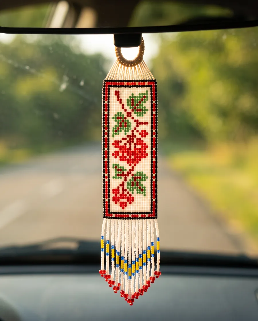 Loom-woven beaded car hanger with a red rose motif and fringe on a rear-view mirror